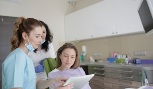 Junge Zahnärztin berät Patientin in eigener Praxis